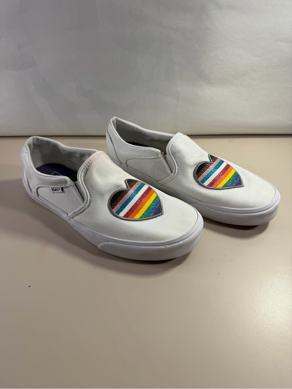 Vans woman’s White Slip-On Sneakers with Rainbow Heart Patch